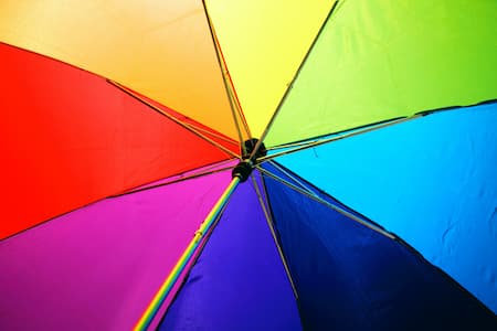 Vue du dessous un parapluie divisé en 8 quartiers chacun d'une couleur vive de l'arc en ciel