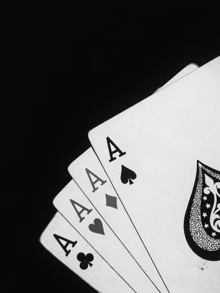 sur fond noir, une main de cartes comprenant quatre as noirs